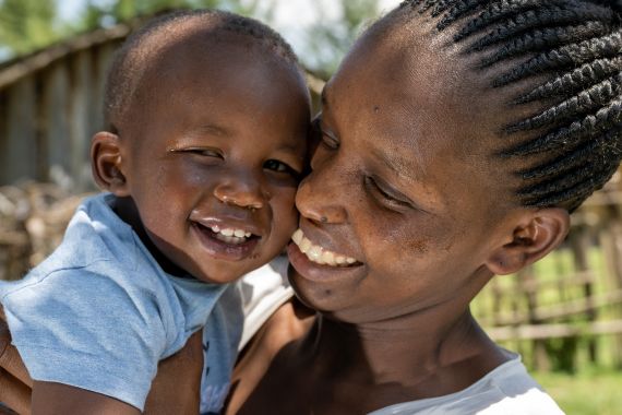 Portrait einer Frau und ihrem kleinen Sohn, beide lächeln.