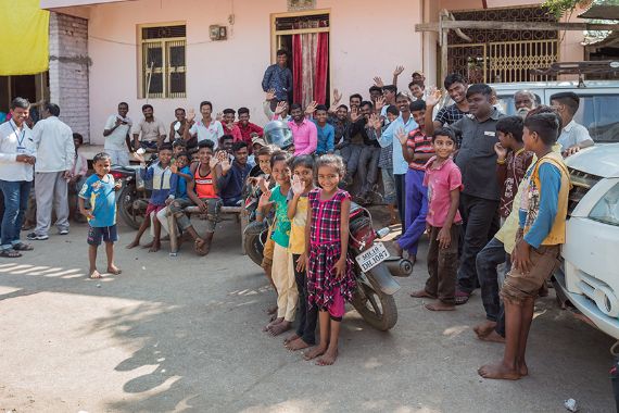 Eine große Gruppe von Kindern und Erwachsenen stehen vor einem Gebäude
