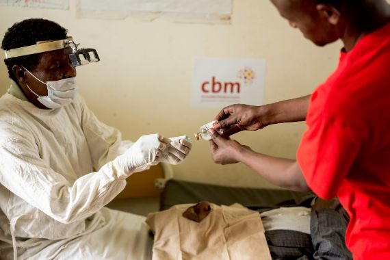 Eine afrikanische Augen-Krankenschwester bereitet einen Trachom-Patienten auf seine Lidoperation vor.