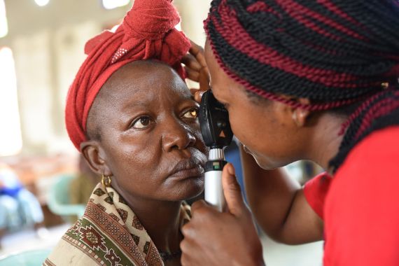 Ein Augenarzt untersucht ein Kind mit der Spaltlampe in Kamerun.
