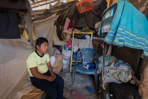 Ein guatemaltekischer Junge mit Downsyndrom in seinem Zimmer