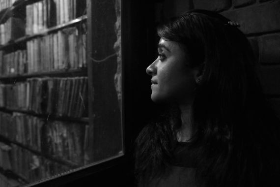 Eine junge Frau schaut aus einem Fenster