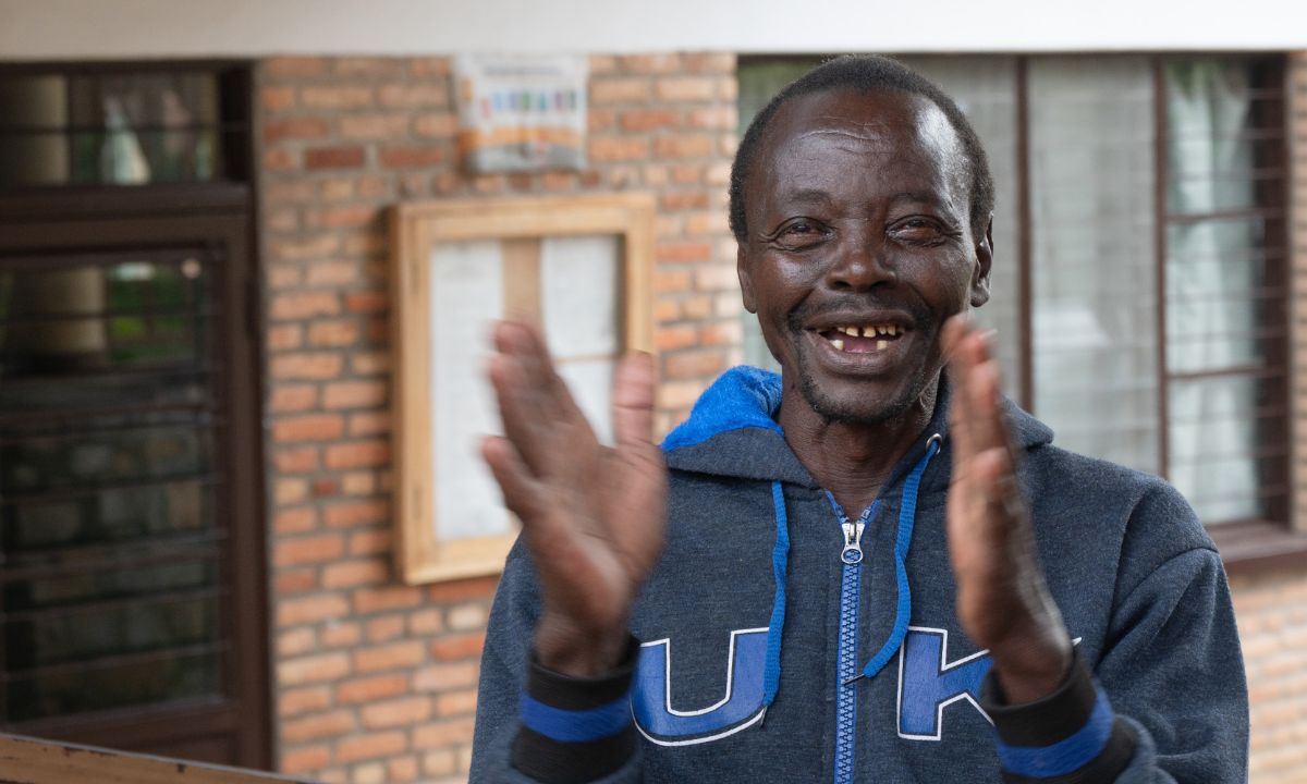 Ein etwa 60-jähriger Mann klatscht lächelnd in die Hände.