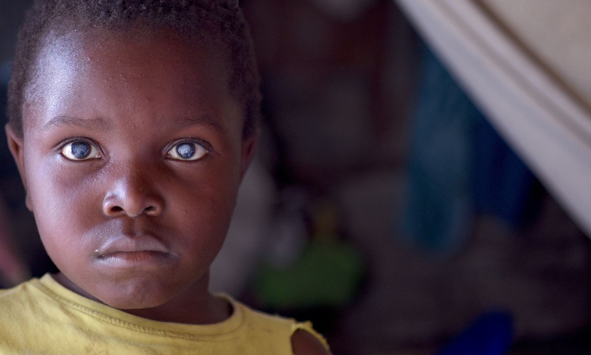 Traurige schauender kleiner Junge mit hell schimmernden Pupillen