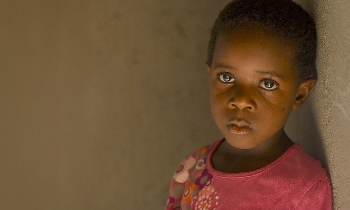 Ein kleines Mädchen mit hell schimmernden Pupillen.