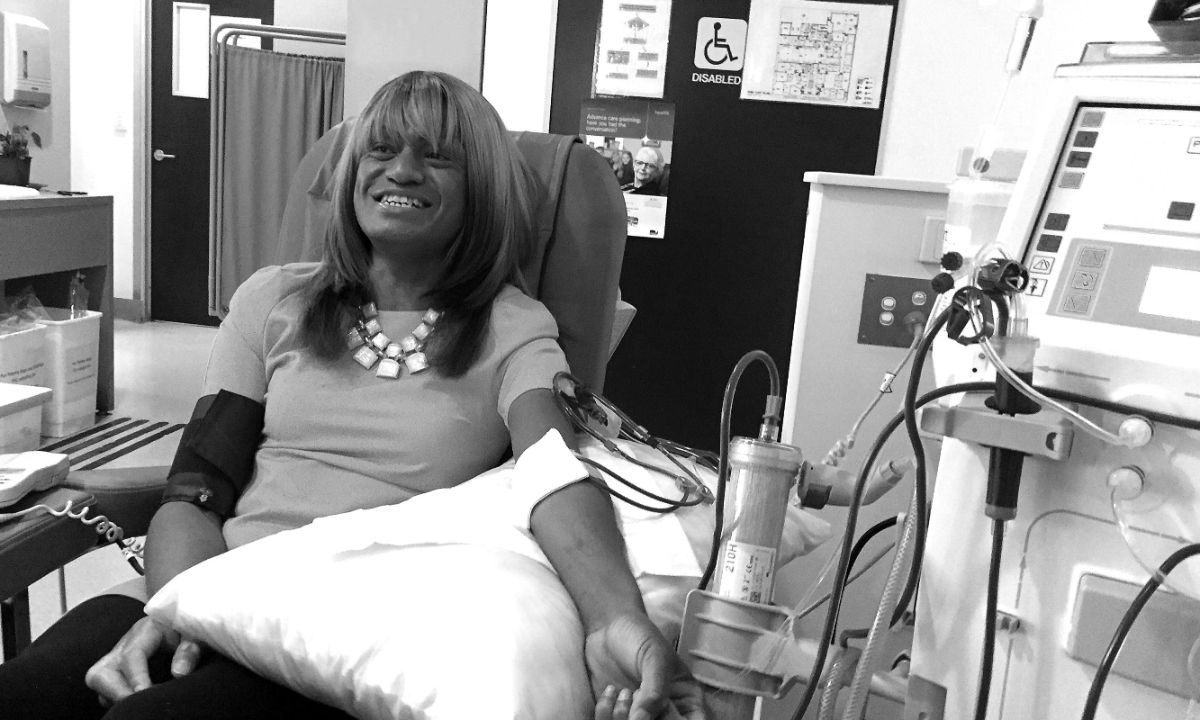 Eine lächelnde Frau bekommt eine Infusion.