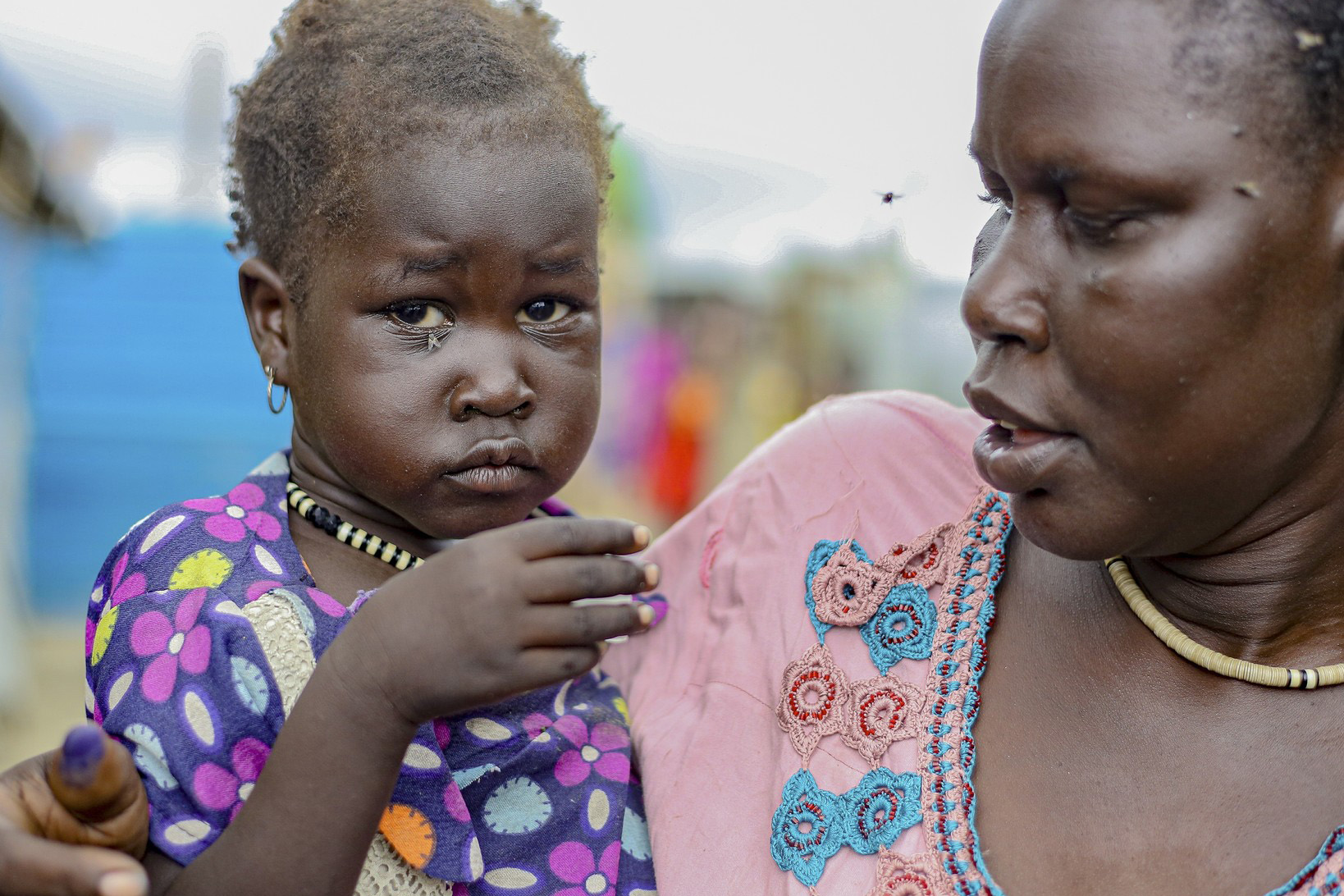 Afrikanisches Kleinkind auf dem Arm einer Frau