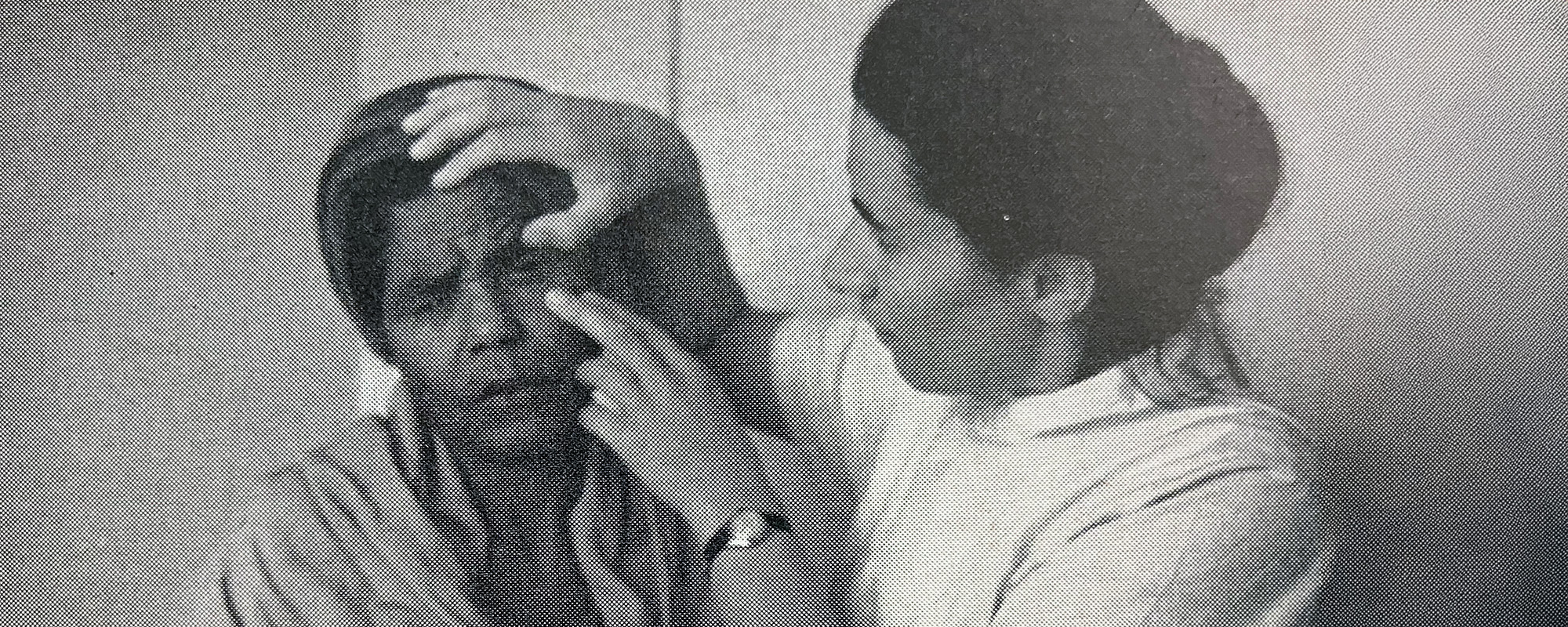 Eine Frau im weißen Kittel untersucht das Auge einer anderen Frau.